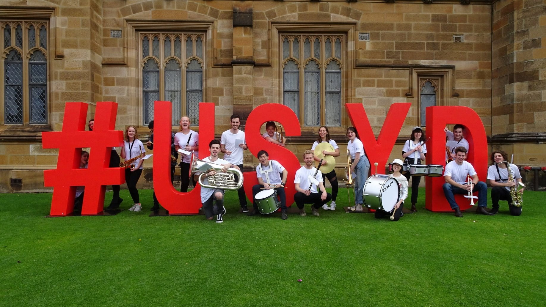 SUMBA performing in front of the #USYD sign at the University of Sydney